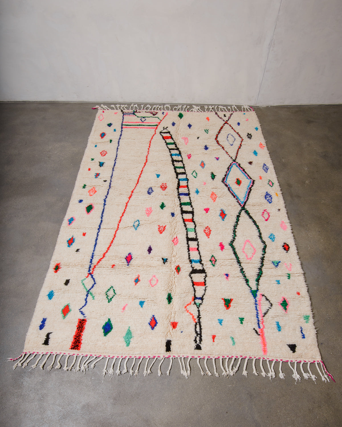 Berberlin Azilal rug made of fluffy wool and cotton, laying flat on a concrete floor.